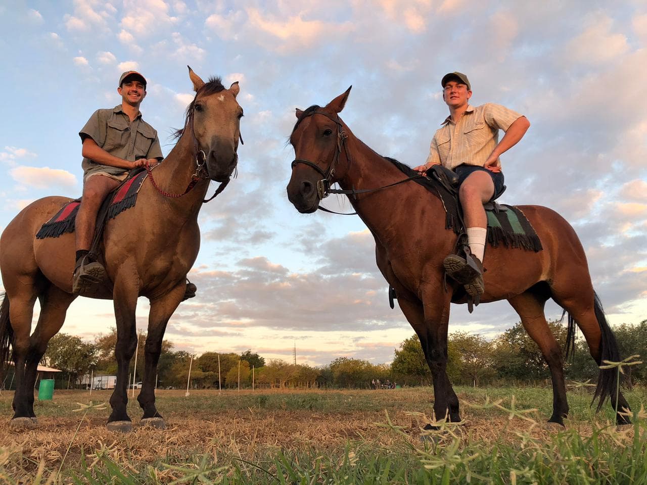 Two riders moving through open grassland